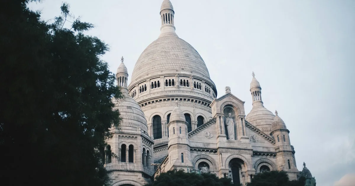 The white domes of the Sacré-Cœur against a pale sky