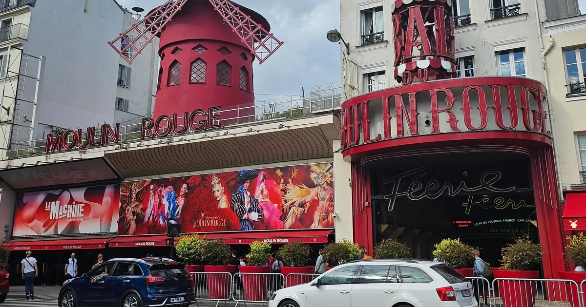 Die Fassade des Moulin Rouge mit seiner roten Windmühle bei Tag